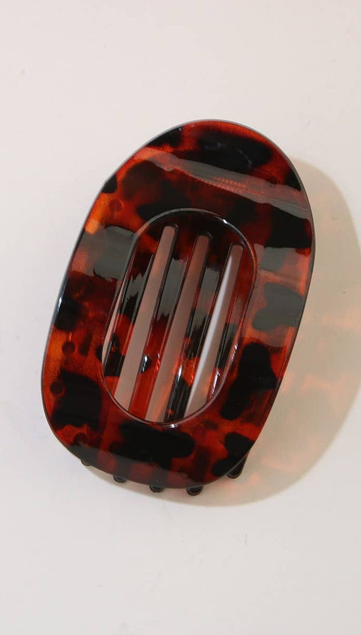 Tortoiseshell hair clip with black and red hues, glossy finish.