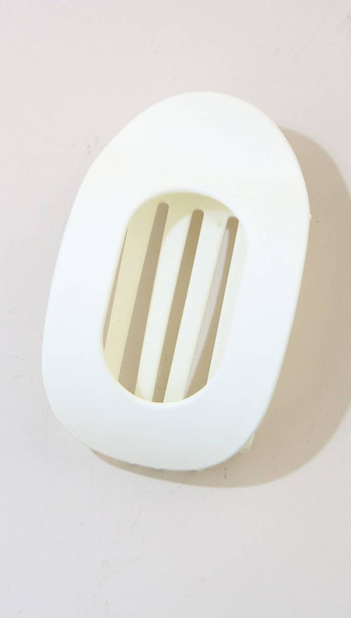 White oval soap dish with slotted design for drainage, made of plastic or ceramic.