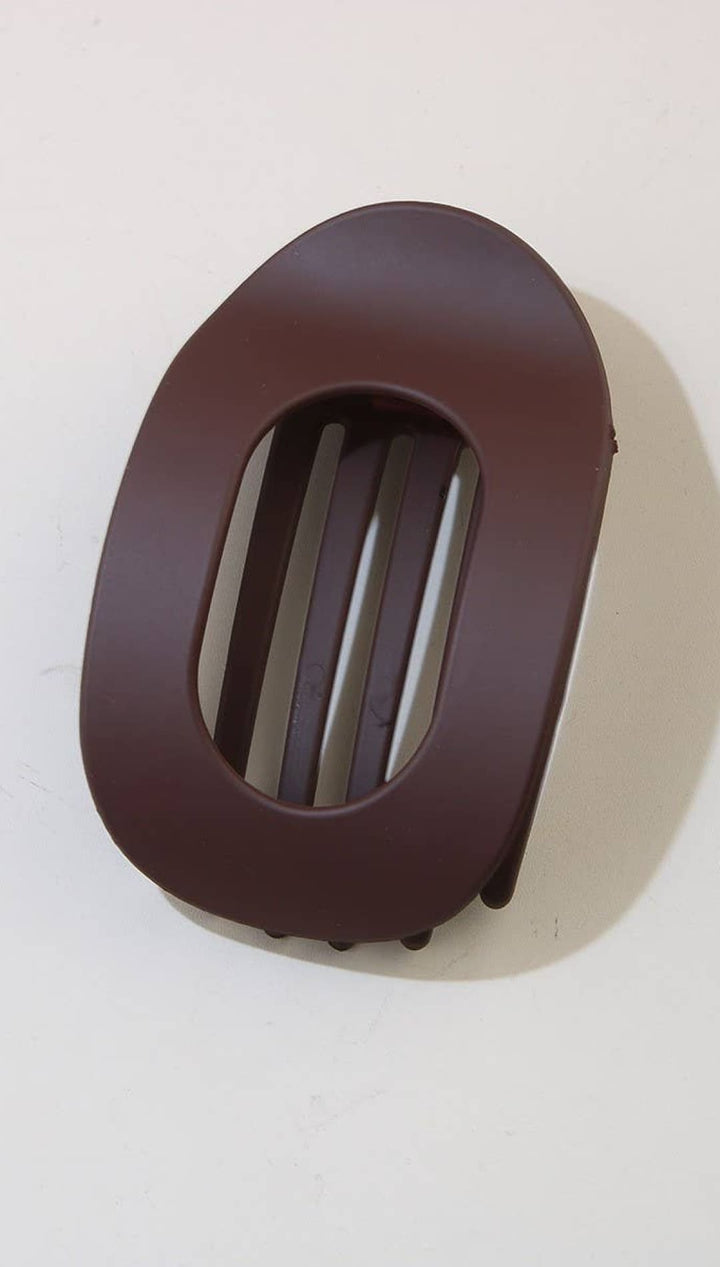 Brown leather belt buckle with slotted design for easy adjustment.