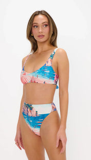 A vibrant, tropical-themed bikini set featuring a blue and pink ocean scene with cliffs and tiny figures, crafted from stretchy fabric.