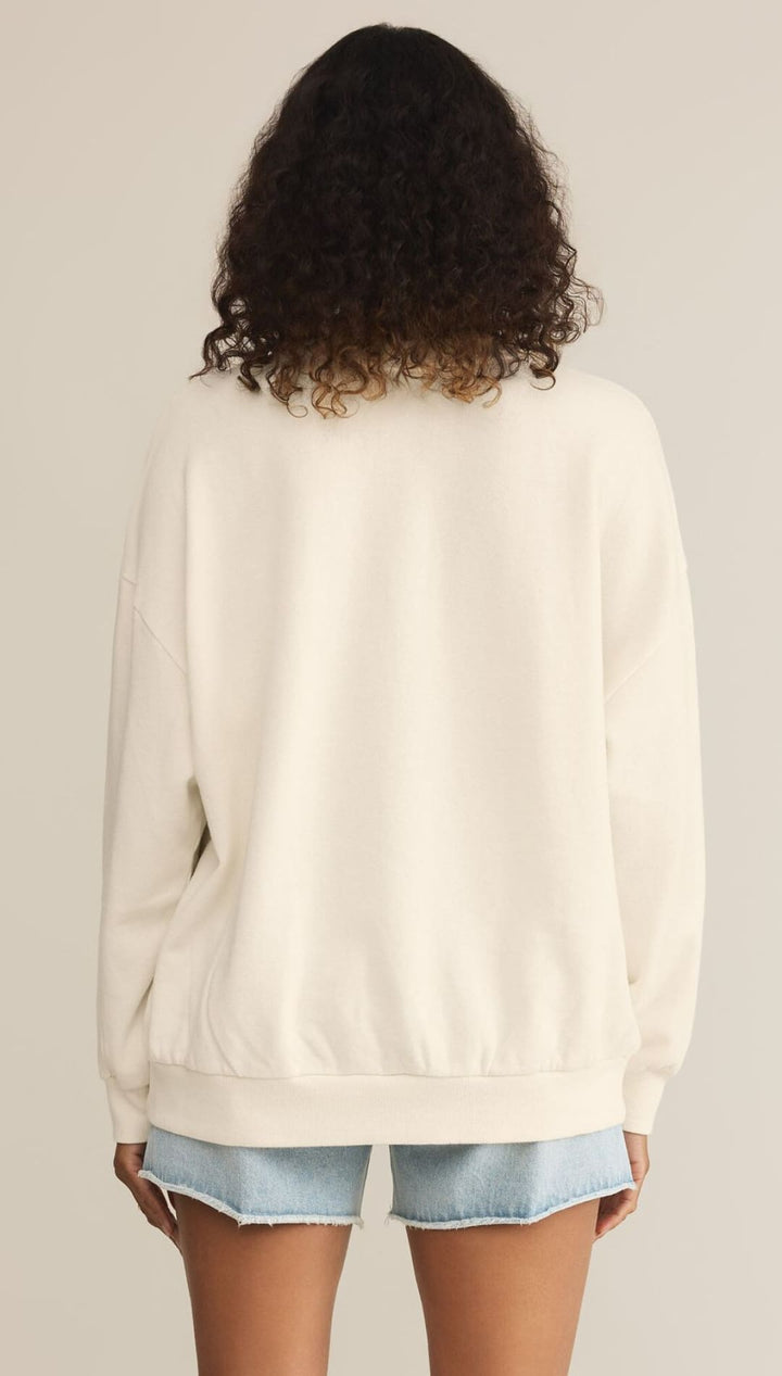 White crewneck sweatshirt worn with denim shorts.