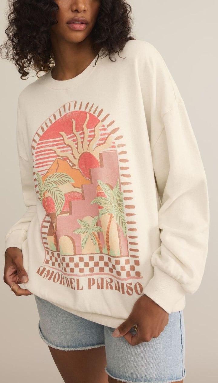 White sweatshirt featuring a pink and coral tropical paradise graphic design with palm trees and sunset motif.