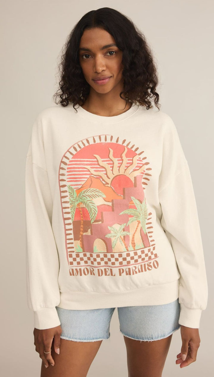 White sweatshirt featuring a pink and green graphic design with elephants and ’Amor Del Paraiso’ text.