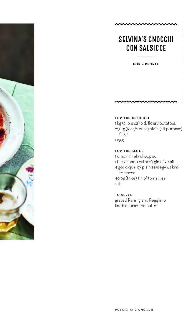 White bowl with red sauce and shrimp, green napkin underneath.