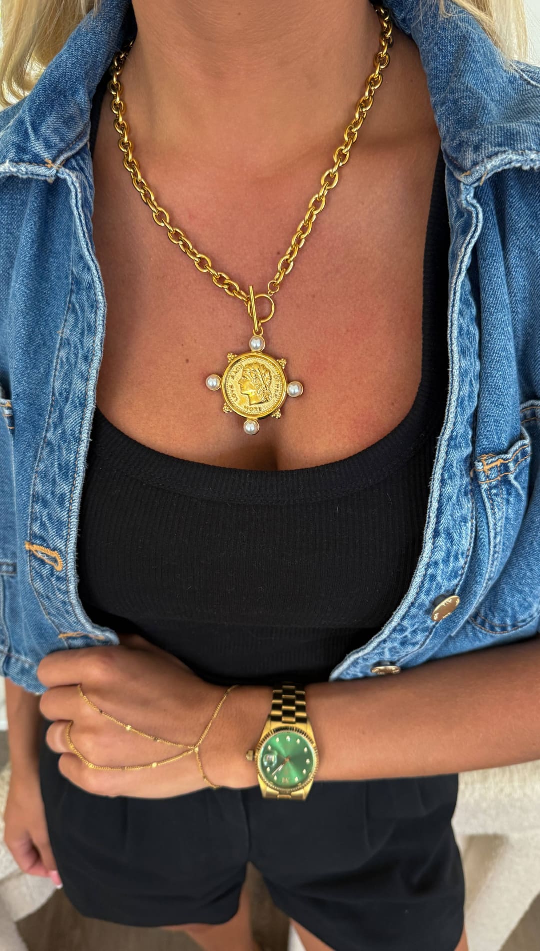 Gold coin pendant necklace with a bold, sunburst design and pearl accents.
