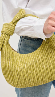 Woven yellow handbag with knotted handle.