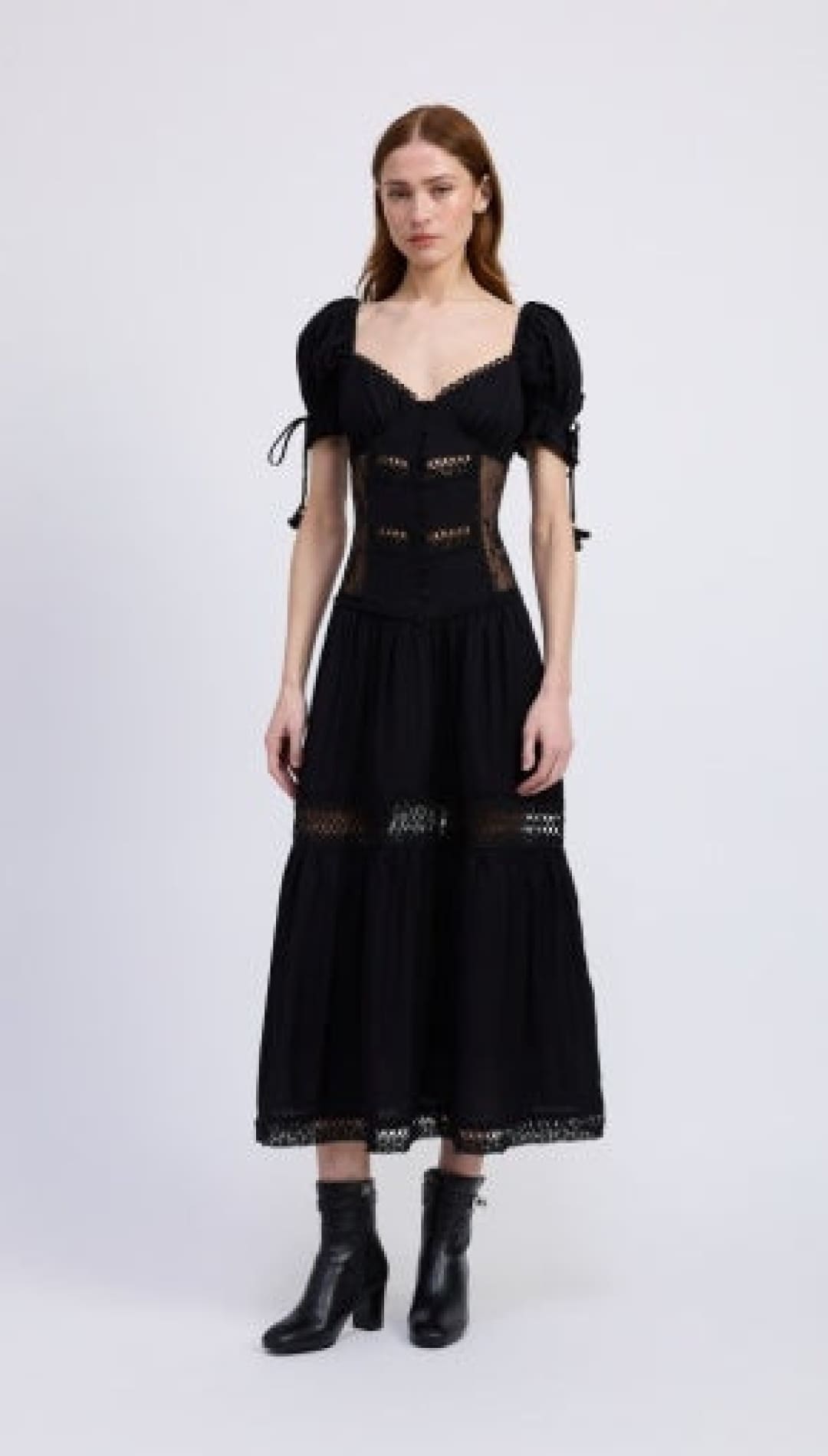 A black midi-length dress with puff sleeves, a sweetheart neckline, and lace-up details.