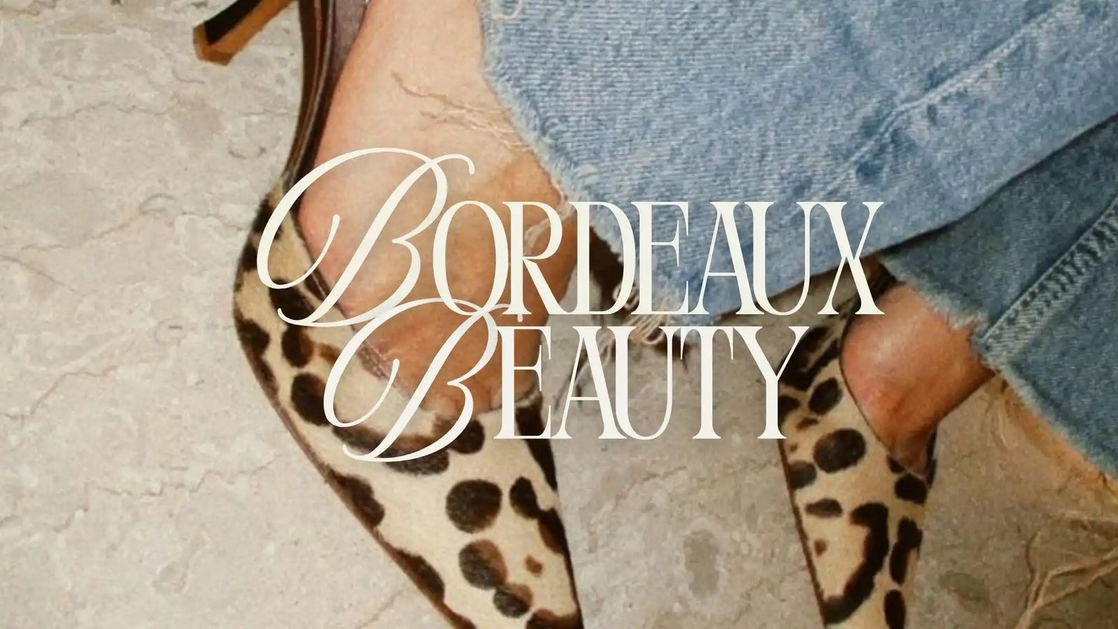 A person’s leg and foot in a leopard print high heel, wearing blue jeans.