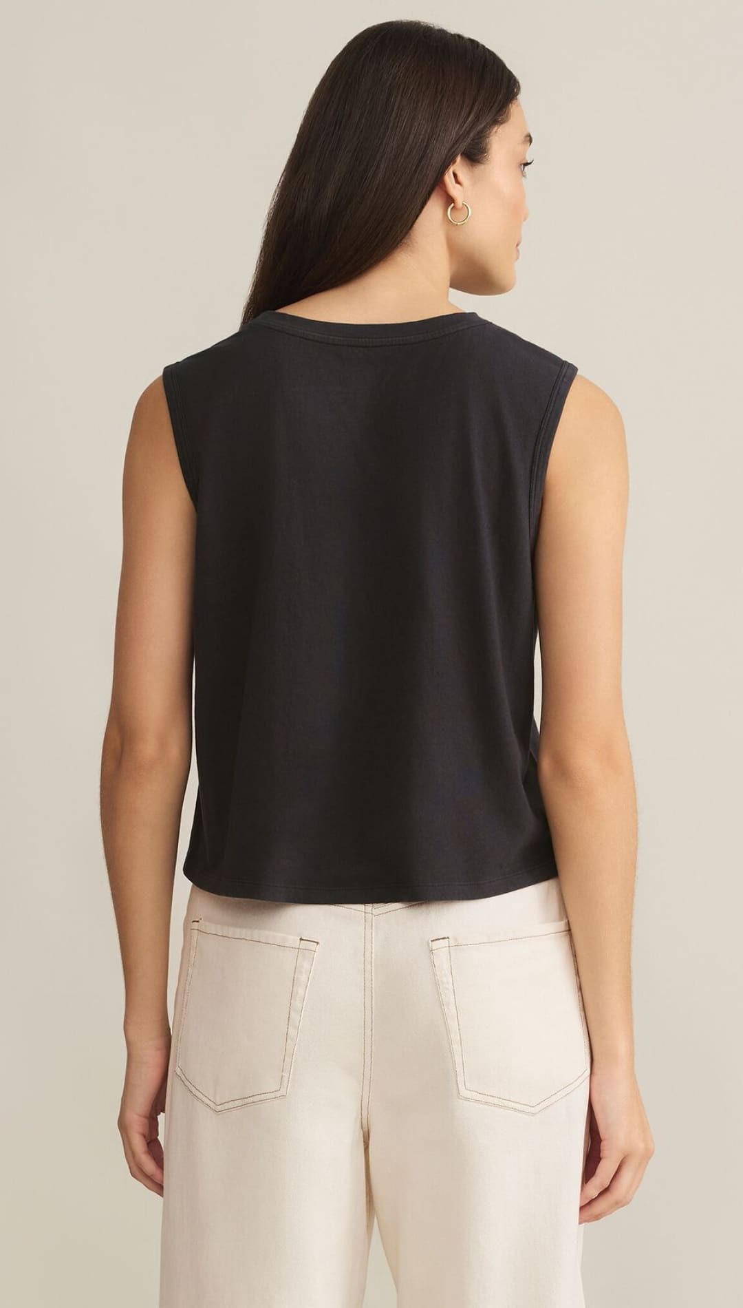 Black sleeveless top with cream-colored pants.