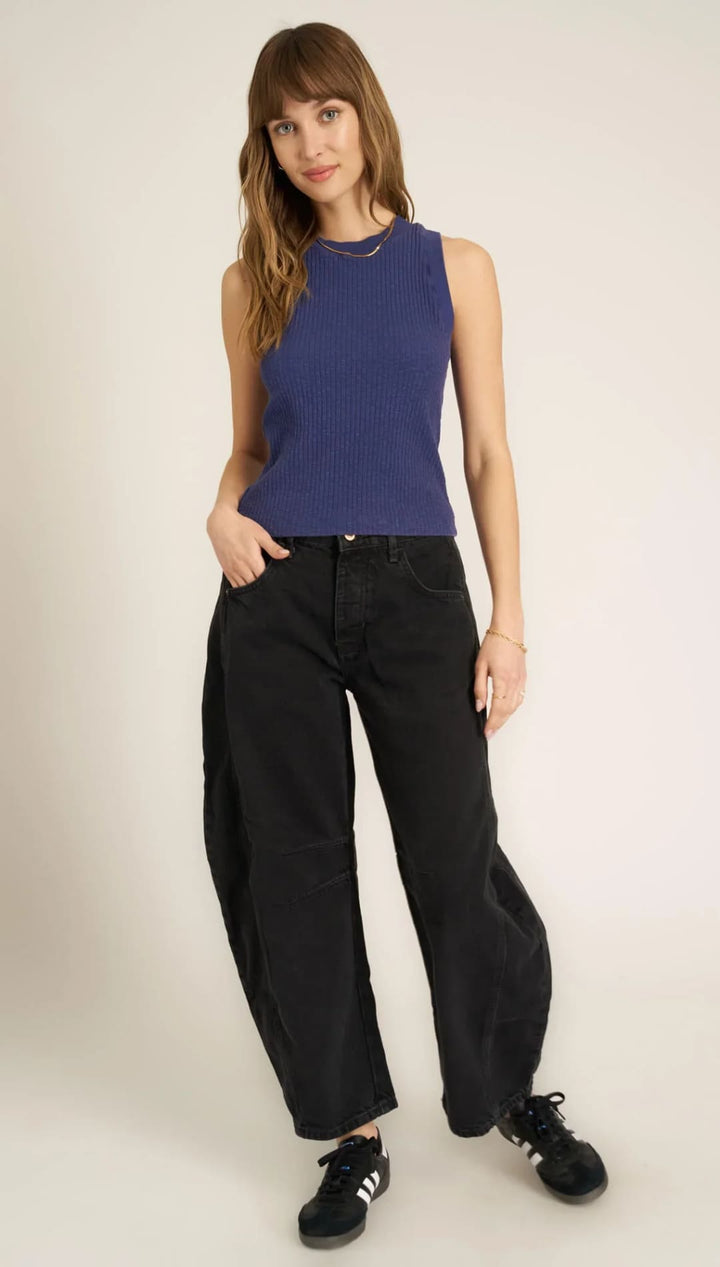 Woman in blue tank top and black jeans.