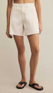 White denim cutoff shorts with a raw hem.
