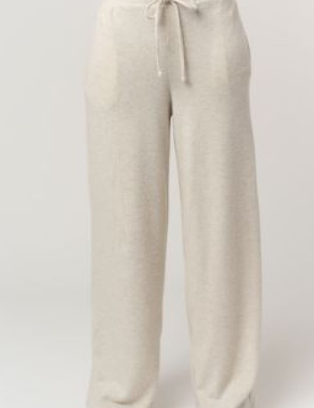 Cream-colored, loose-fitting pants with a drawstring waistband and subtle vertical stitching details.
