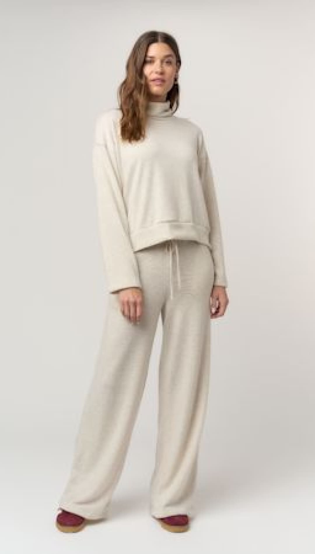 Beige turtleneck sweatshirt and matching wide-leg pants set.
