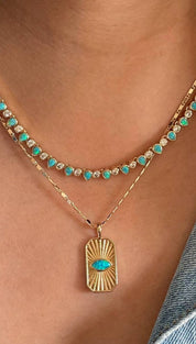 Layered gold necklaces with turquoise accents.