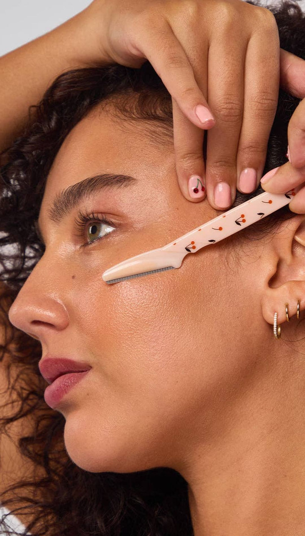 Pink plastic brow razor with black cat design