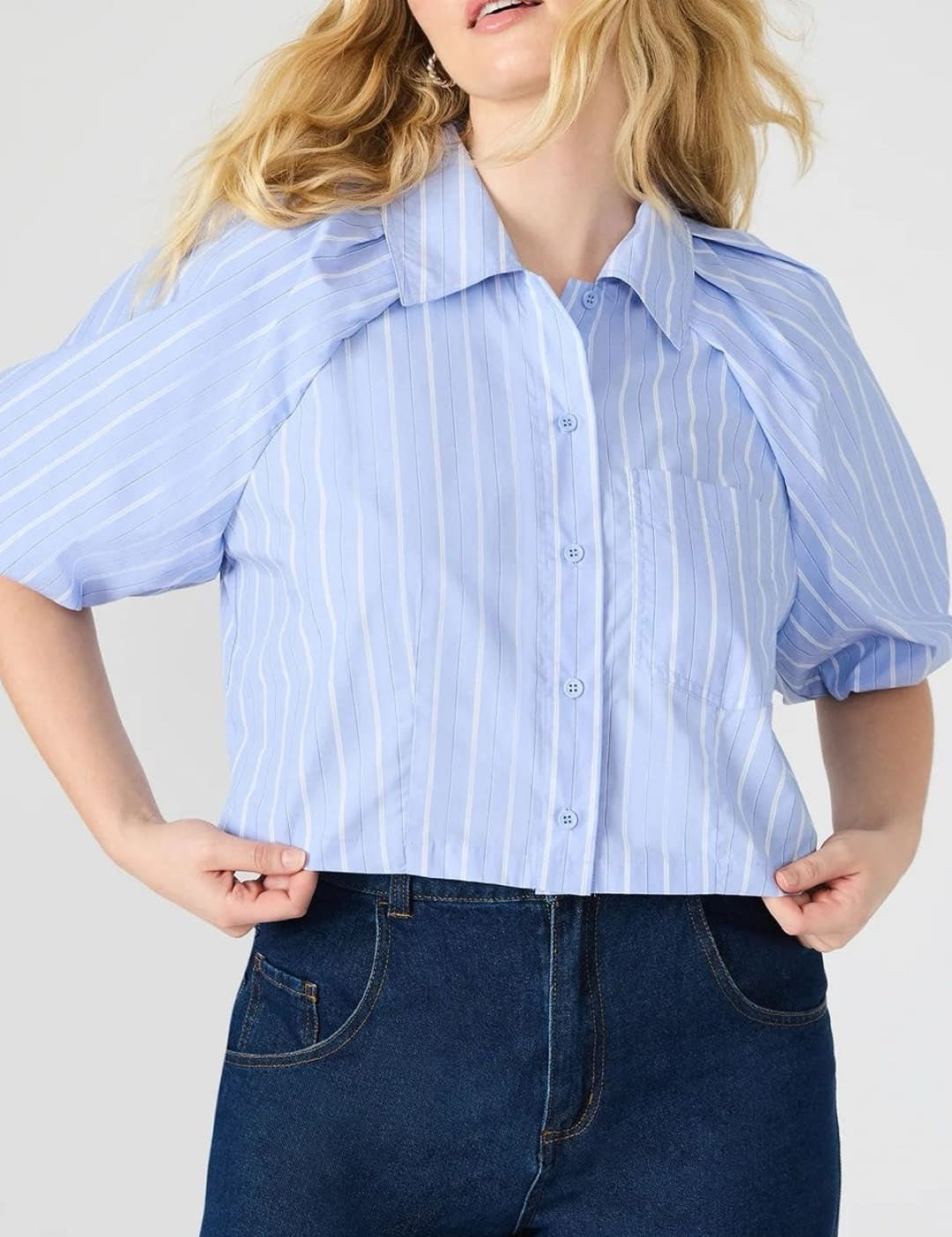 Woman in a striped, short-sleeved blouse and dark jeans.
