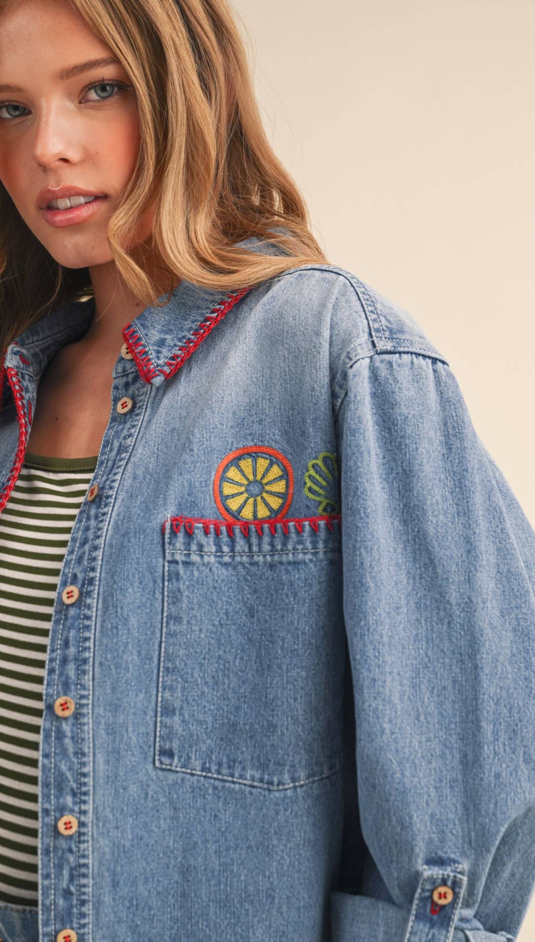 Blue denim shirt with colorful embroidered citrus design on the chest pocket and red stitching along the collar.