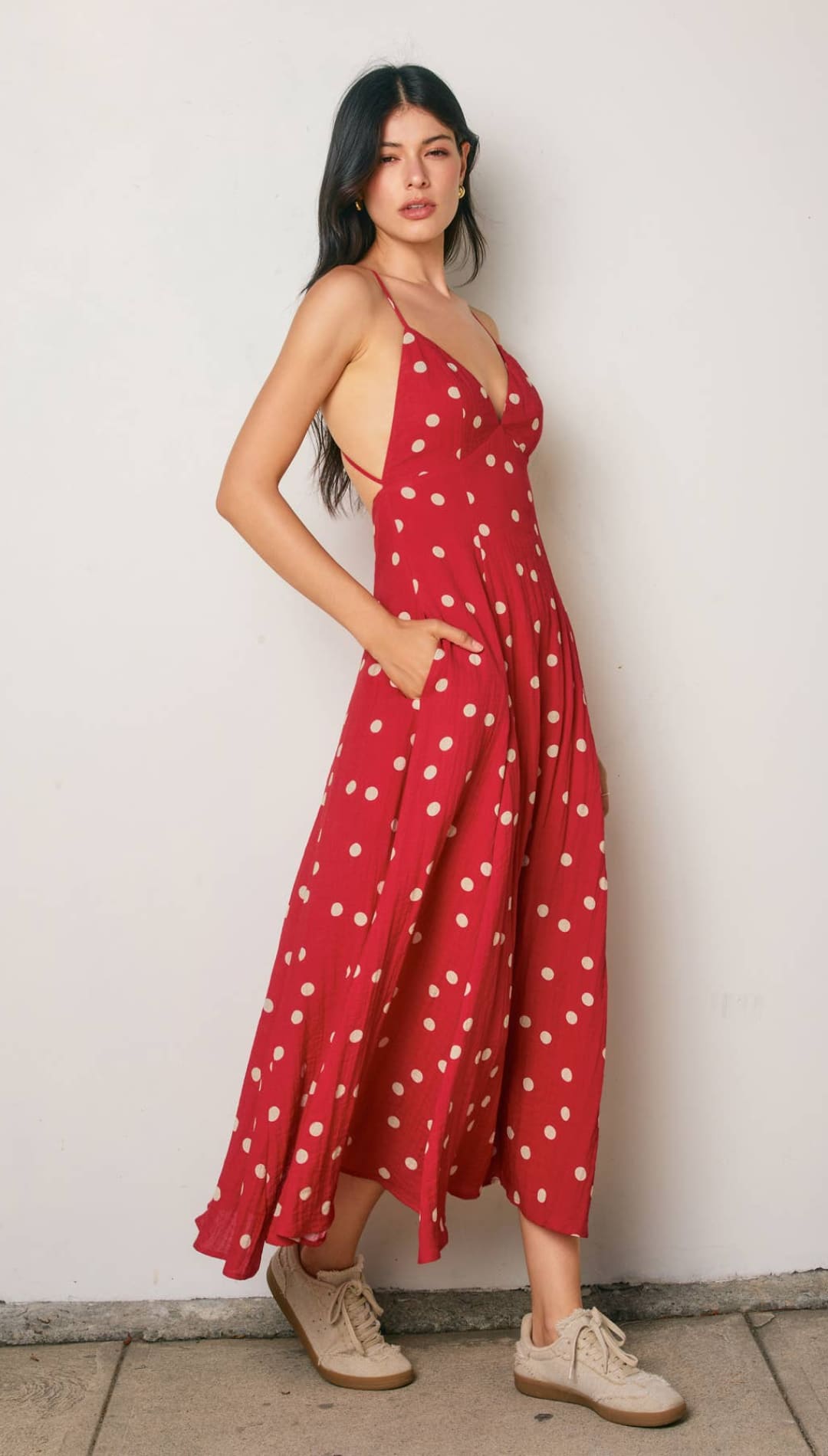 Red polka-dot maxi dress with thin straps and side pockets.