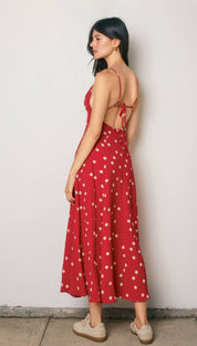 A red midi dress with white polka dots and thin spaghetti straps, featuring a back tie detail.