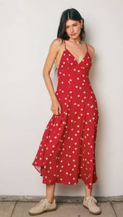 A red polka-dot midi dress with thin spaghetti straps and a v-neckline.