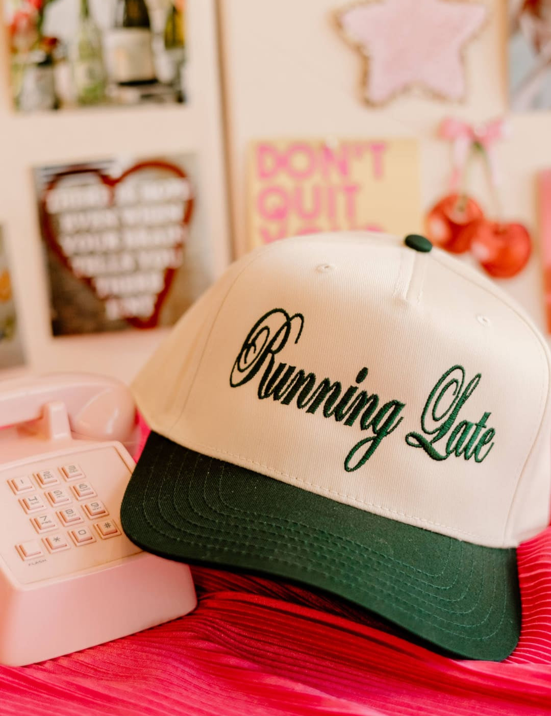 White and green ’running late’ trucker hat with black script.