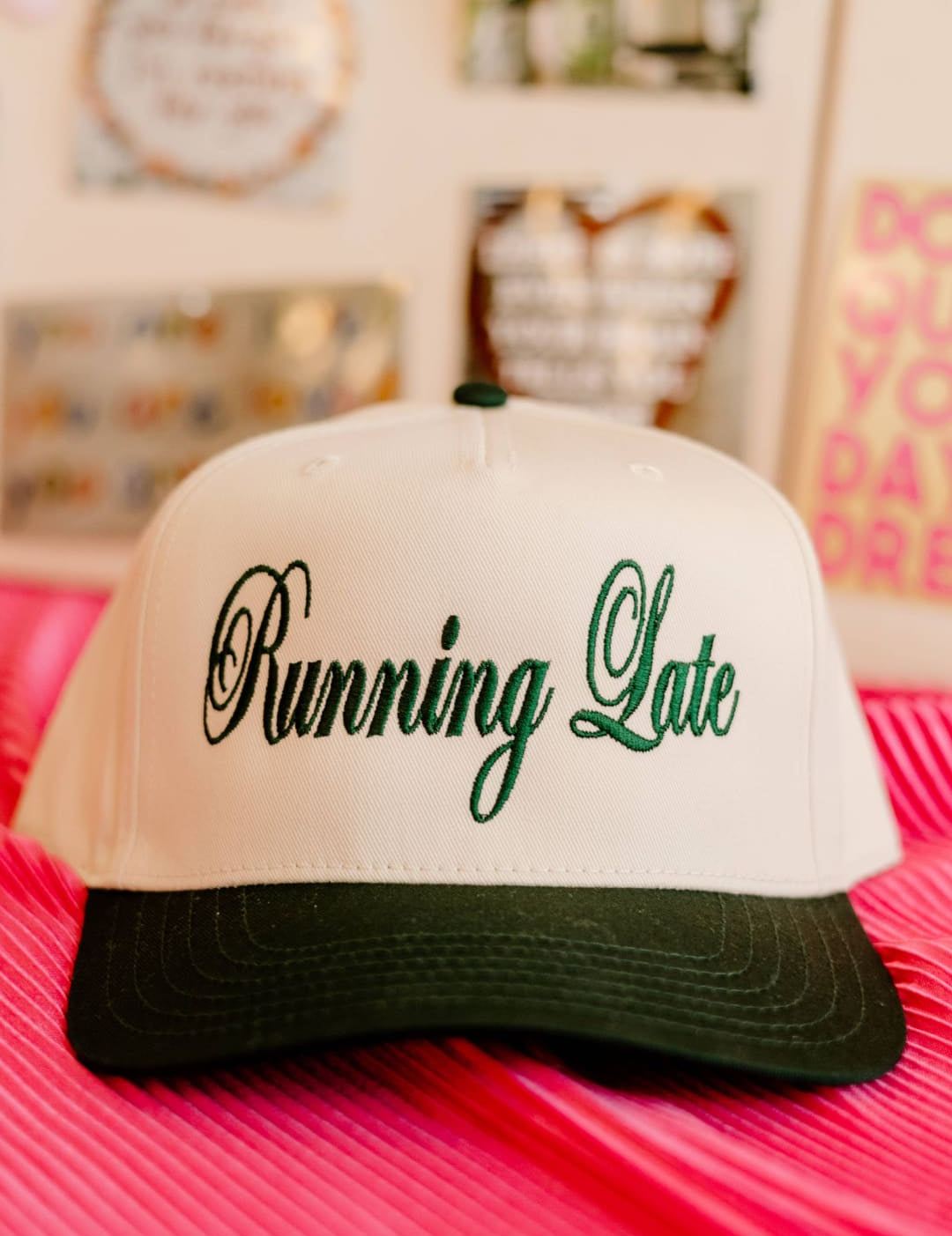 White and green ’running late’ trucker hat with black brim.