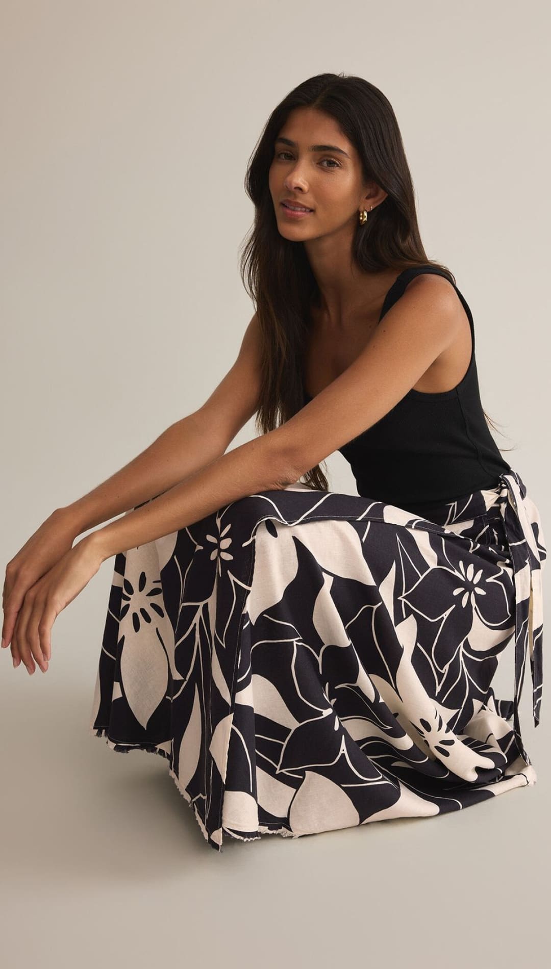 Black and white floral print midi skirt with a black tank top.