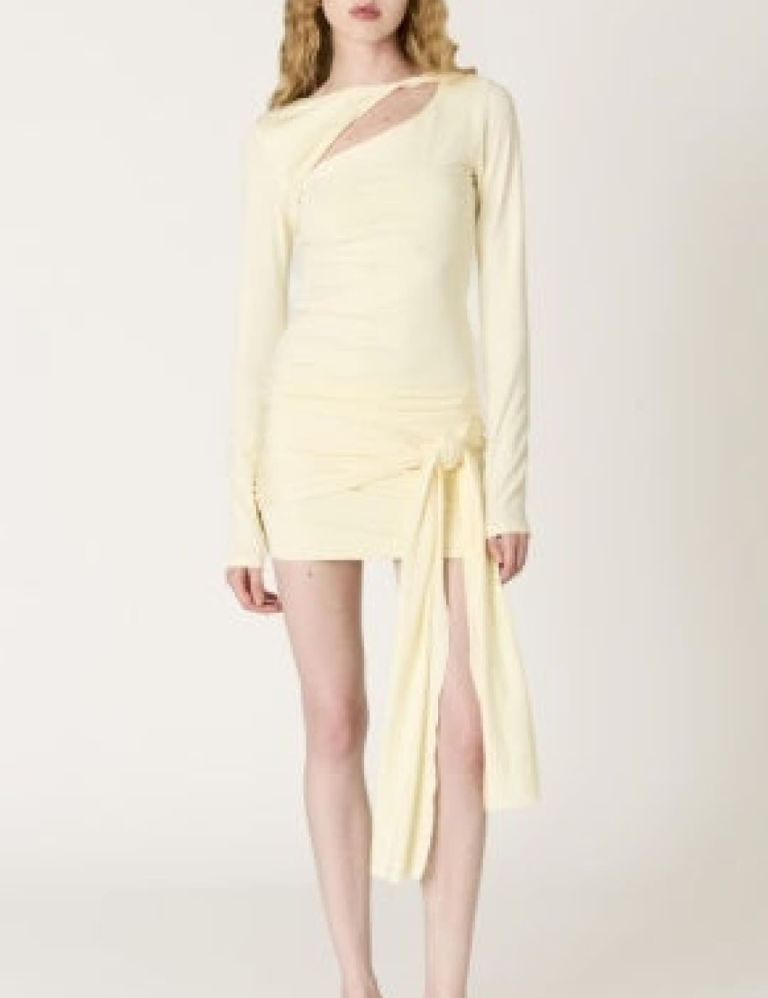 A pale yellow, long-sleeved mini dress with a draped asymmetrical neckline and side slit.