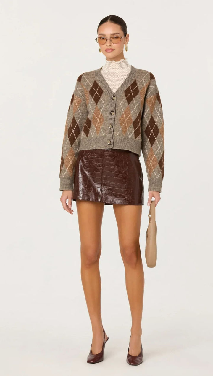 Brown argyle knit cardigan with a textured, faux leather mini skirt.