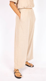Beige wide-leg trousers with a relaxed, flowing silhouette and subtle side seam detailing.