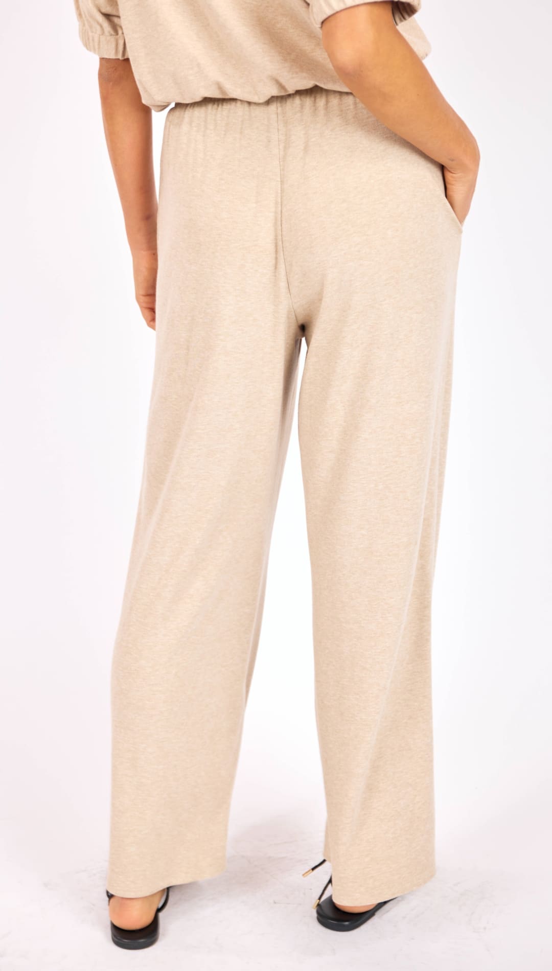 Beige wide-leg trousers with an elastic waistband and a relaxed, flowing silhouette.