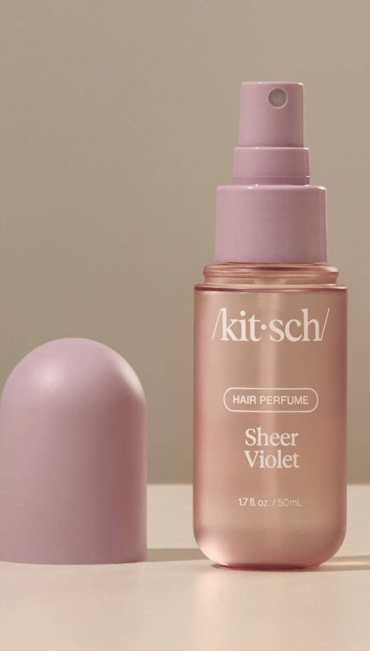 Lavender spray bottle with gold label and cap, designed for hair perfume in sheer violet scent.