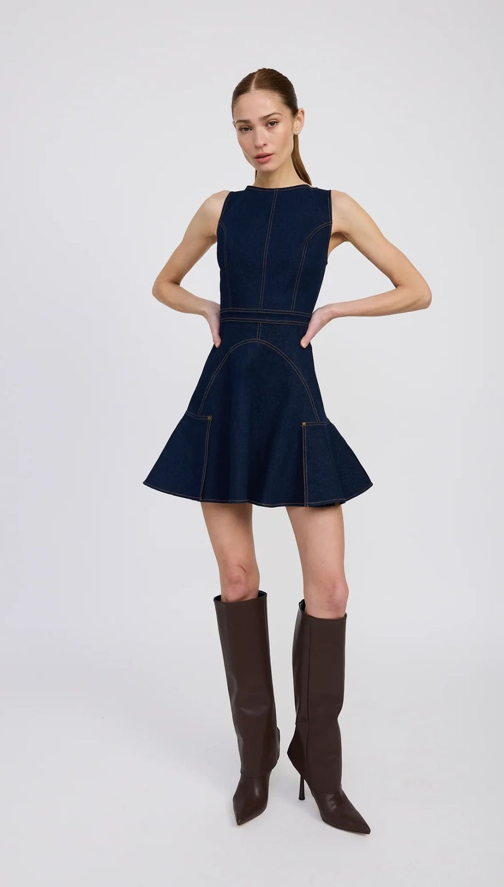 Sleeveless navy denim fit-and-flare mini dress with white stitching.