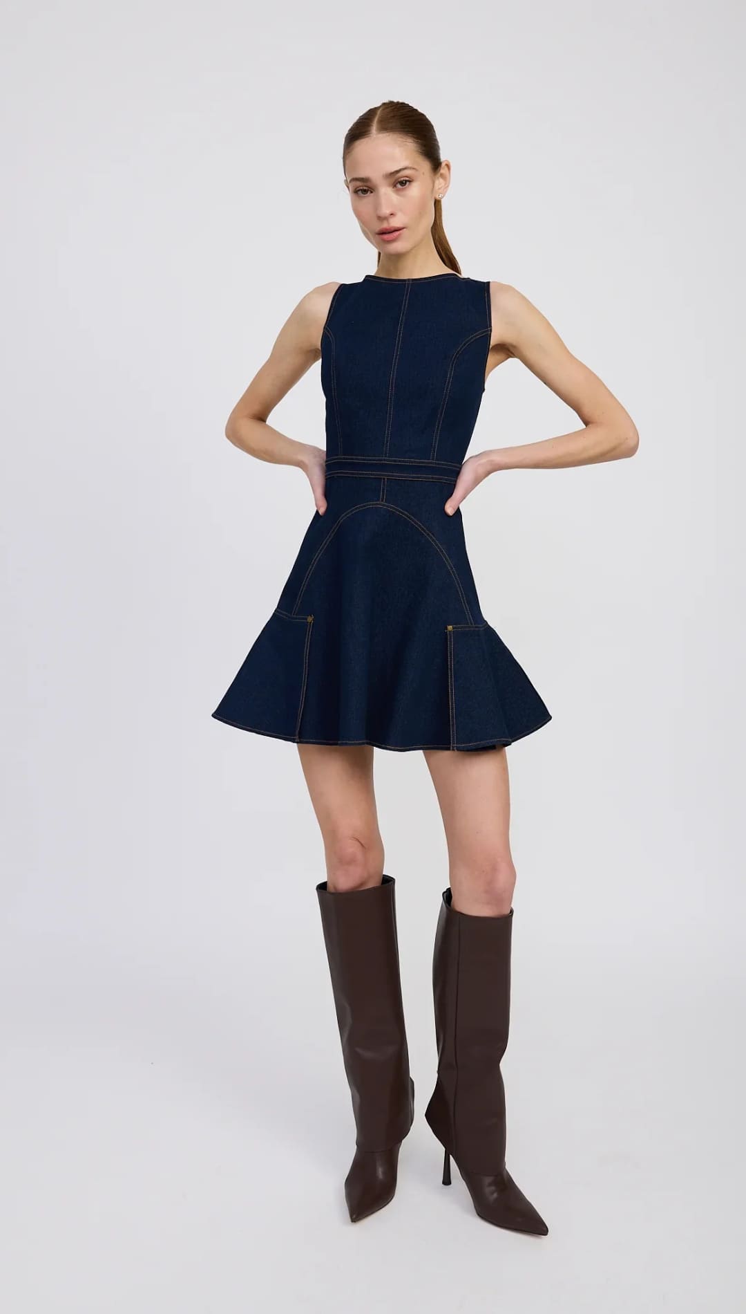 Sleeveless navy denim fit-and-flare mini dress with white stitching.