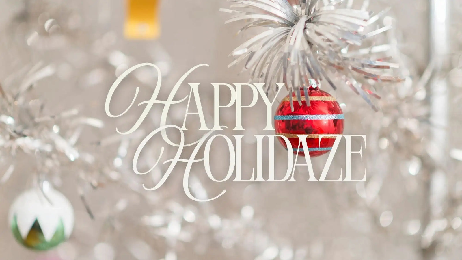 Silver tinsel christmas tree ornament with red and white stripes, clear glass baubles, and a green drop-shaped decoration.