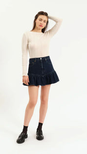 Denim ruffle skirt with frayed hem and black socks.