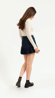 Denim skirt with ruffled hem and black lace-up boots.