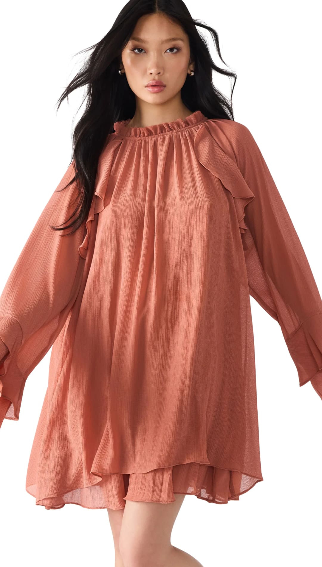 A long-sleeved, ruffled, salmon-colored mini dress.