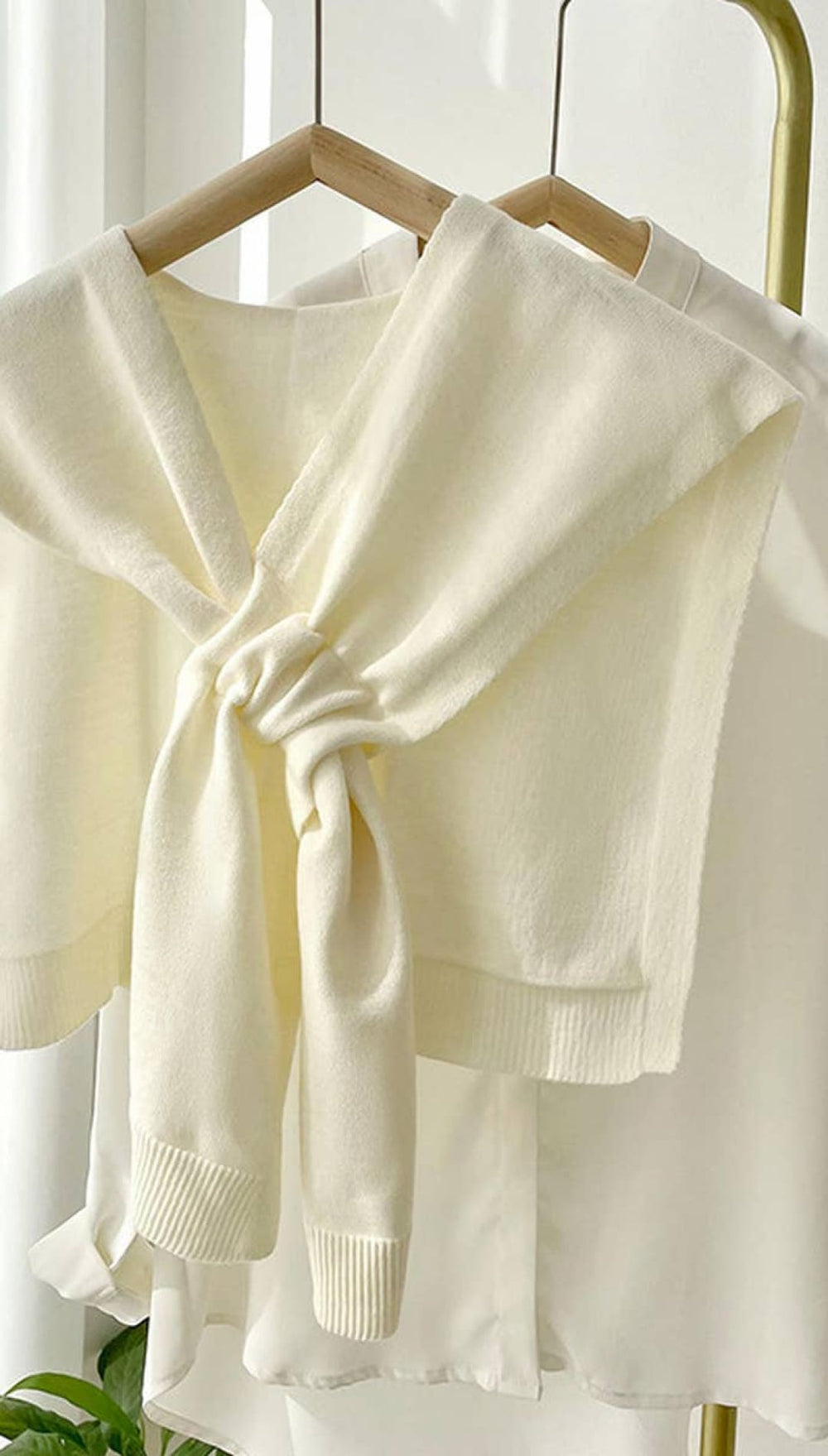 Cream-colored knitted shawl with a bow tie design, suitable for spring or fall.