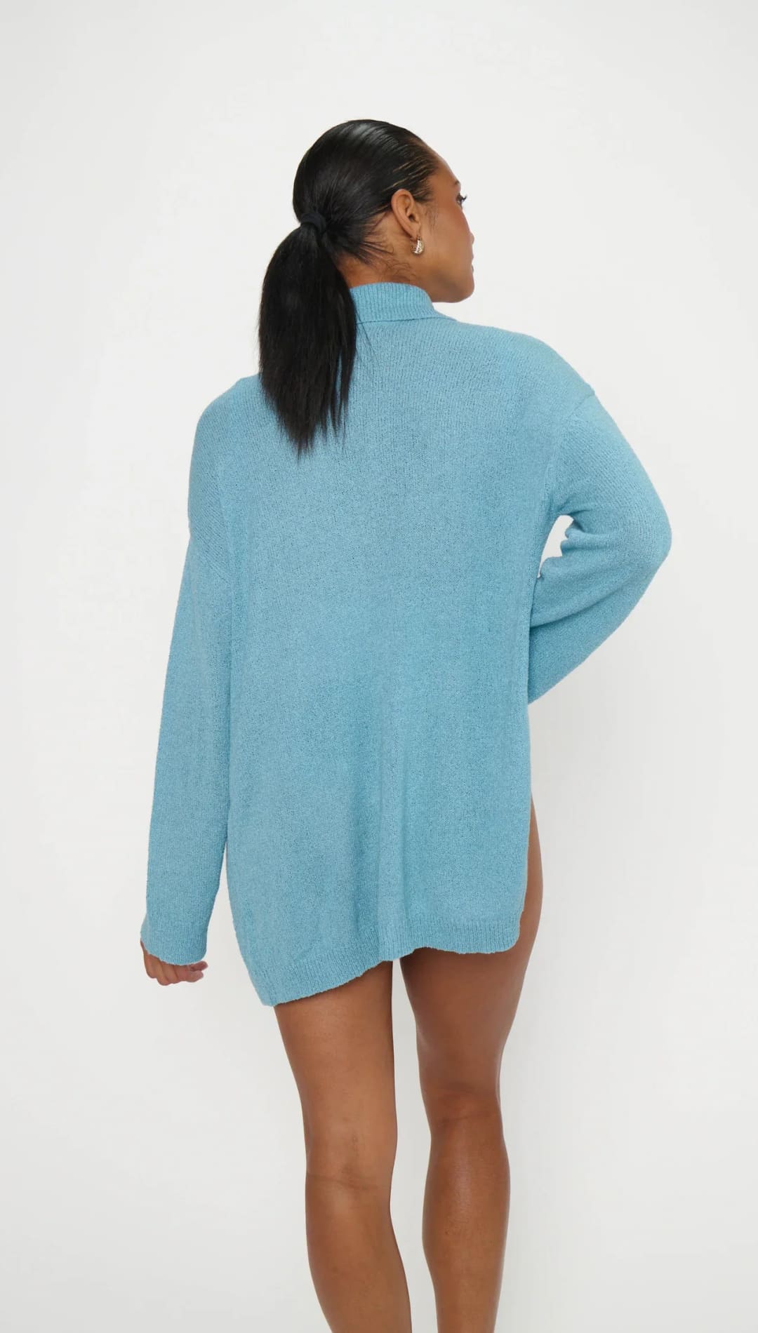 A soft, light blue oversized turtleneck sweater with a loose, flowing fit and ribbed cuffs.