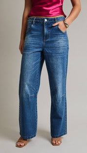 Blue denim jeans with a high waist and straight-leg cut, featuring decorative silver studs along the belt line.