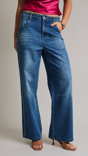 Blue denim flare jeans with silver studs along the sides.