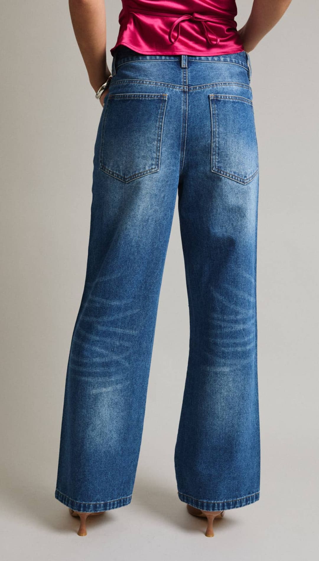 Blue denim wide-leg jeans with a faded wash and classic back pockets.