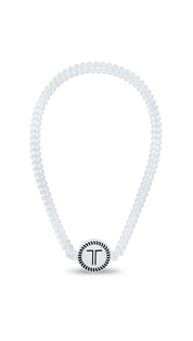 White diamond-studded necklace with a circular pendant featuring the letter ’t’ in silver.