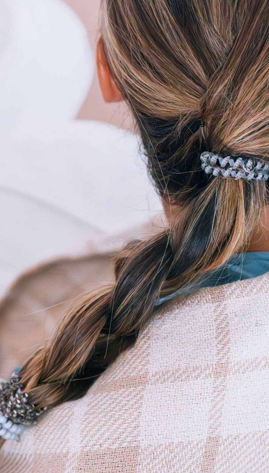 Braided hair with beads and a black scrunchie.