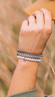 Multi-layered silver and white beaded bracelet with a bohemian design.