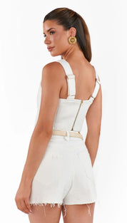 Woman in white denim shorts and top.