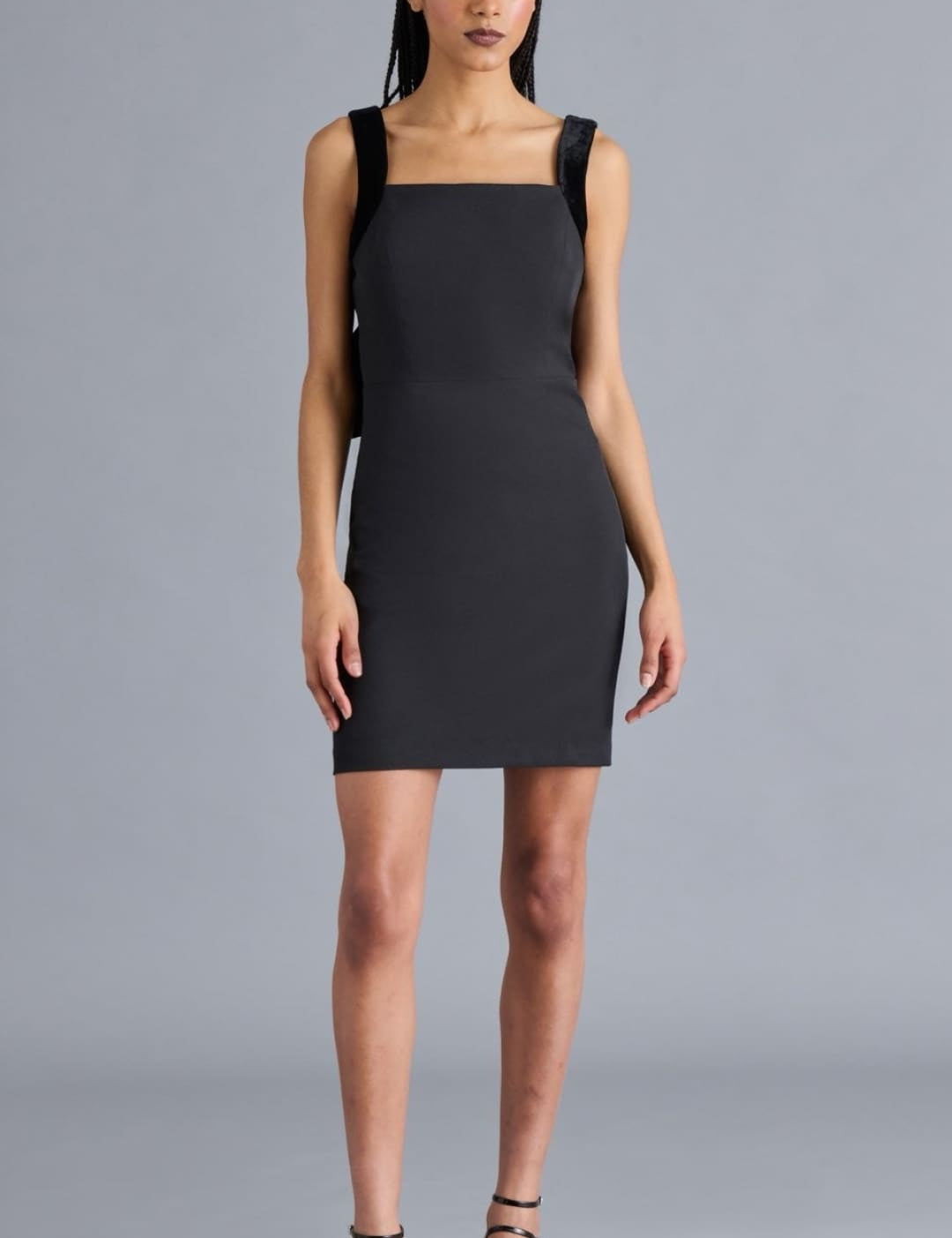 Black sleeveless mini dress with square neckline and wide straps.