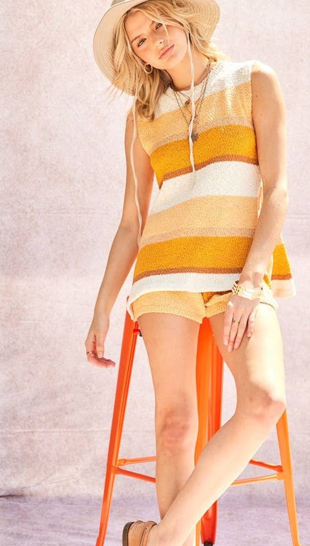 Yellow and white striped knit sleeveless top with a relaxed, textured fabric.