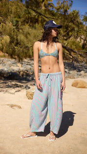 Woman wearing a blue and white striped wide-leg pants with a matching patterned bikini top
